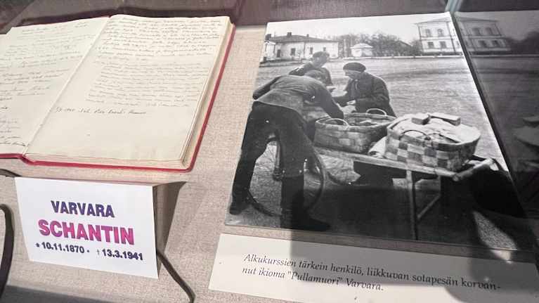 Valokuva naisesta, joka myy sotilaille leivonnaisia.