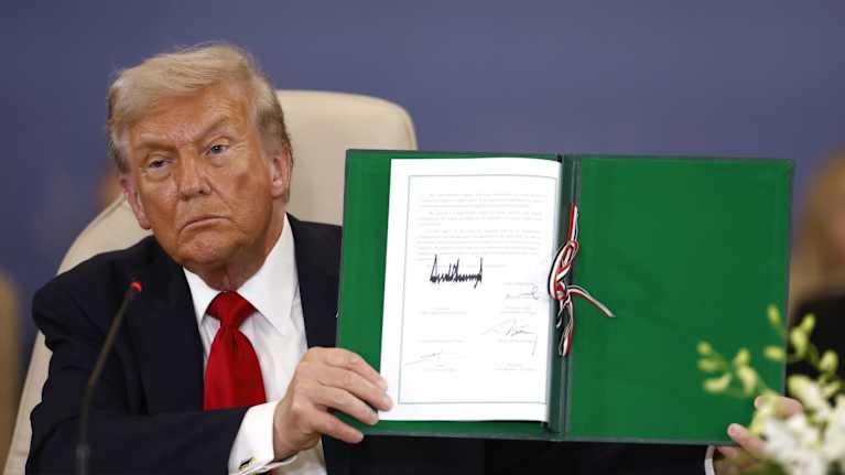 President Donald Trump visar upp ett dokument som gäller fred i Gaza. 