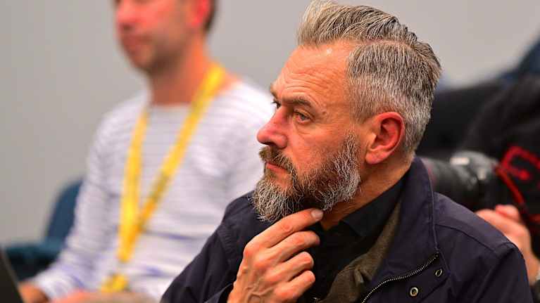 Olof Lundh kliar sig i skägget.