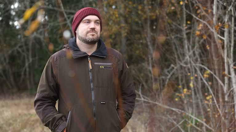 Suomen riistakeskuksen hirvitalousasiantuntija Antti Rinne seisoo metsän reunassa ja katsoo oikealle horisonttiin.