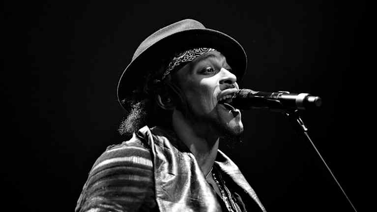 Michael Eugene Archer, taiteilijanimeltään D'Angelo laulaa mikrofoniin.