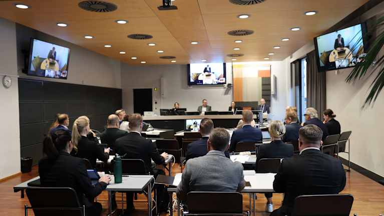 Suuri joukko juristeja on kokoontunut oikeussaliin laajan huumausainerikoksen kokonaisuuden käsittelyyn. Huoneessa on toistakymmentä asianajajaa.