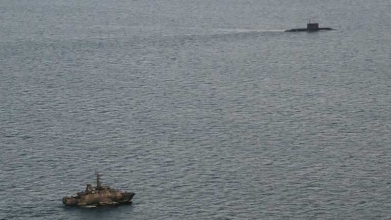 Avomerellä sukellusvene ja armeijan alus.