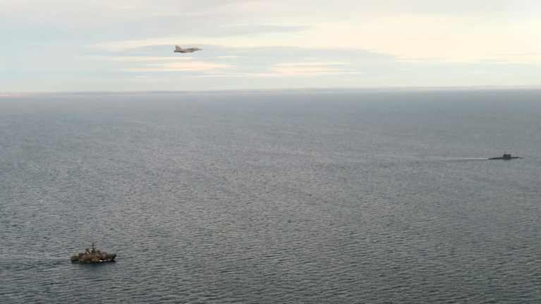 Avomerellä sotilasalus ja sukellusvene. Ilmassa hävittäjä.