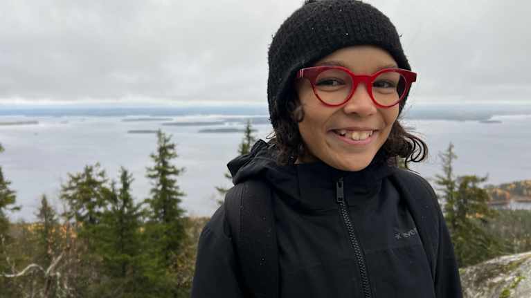 Tyttö seisoo kansallismaisemassa Kolilla.