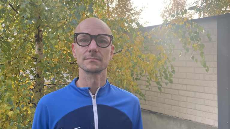 Mies seisoo puun edessä.