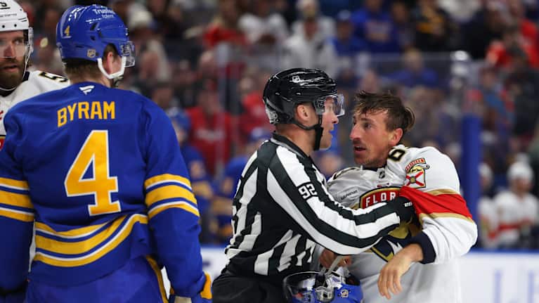 Jääkiekkotuomari pidättelee Brad Marchandia.