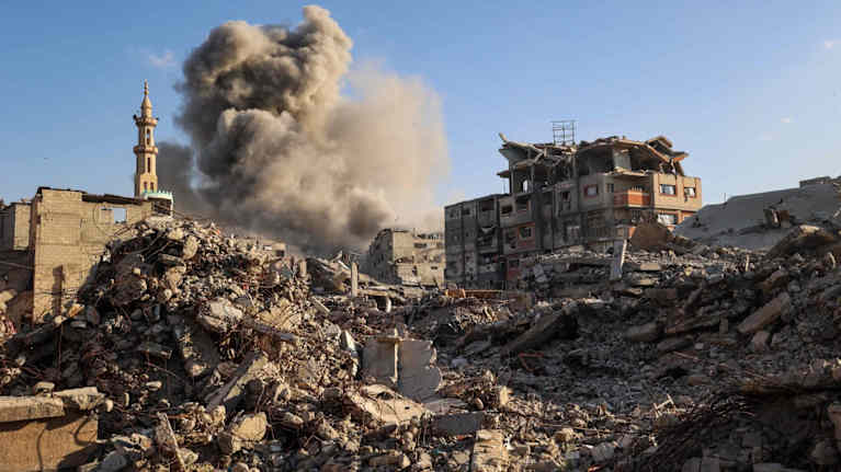 Savu- ja tomupilvi nousee raunioiden keskellä Gazan kaistalla.