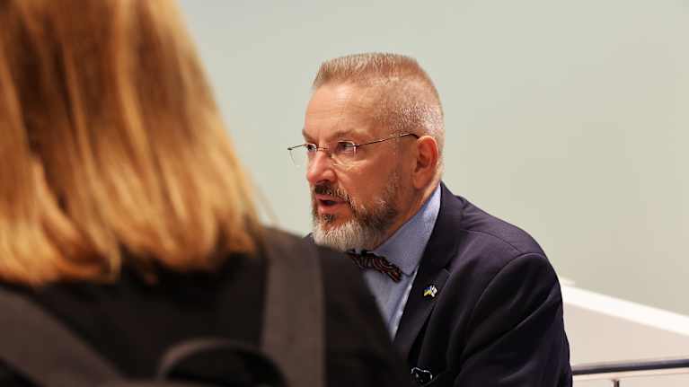 Henkilö puhuu toimittajille.