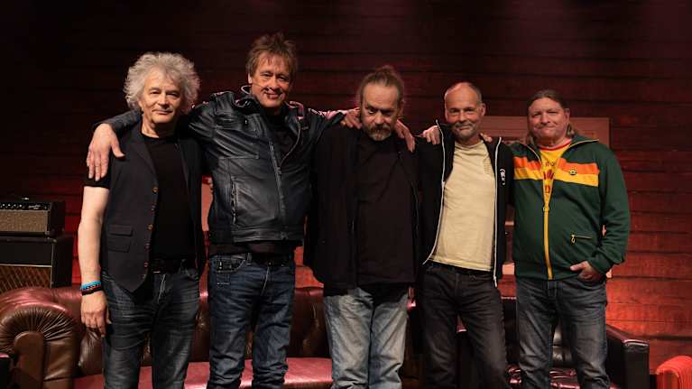 Eppu Normaalin jäsenet rivissä hymyilevät kameralle.