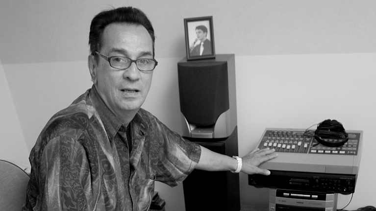 Mies istuu tuolilla musiikkistudiossa.