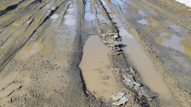 Keväiset kelirikko-olosuhteet tekevät soratiestä haastavan kulkea, kun sulamisvedet ja mureneva pintakerros muodostavat syviä uria ja lammikoita.