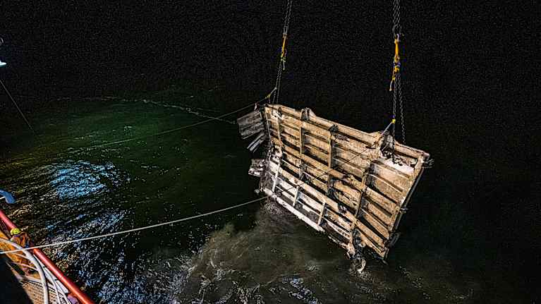 Pimeällä merellä nostetaan merestä Estonian hylyn osaa.