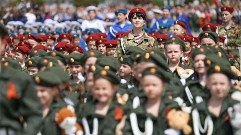 Suuri joukko lapsia sotilaspuvuissa.