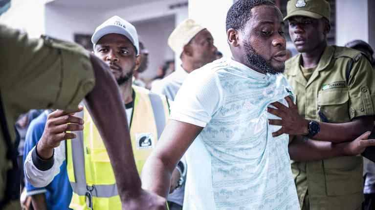 Poliisit pitelevät kiinni henkilöstä.