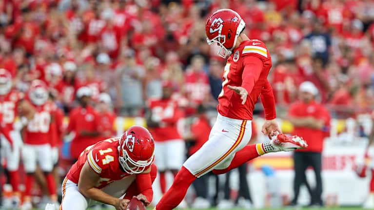 Mies potkaisemassa amerikkalaista jalkapalloa.