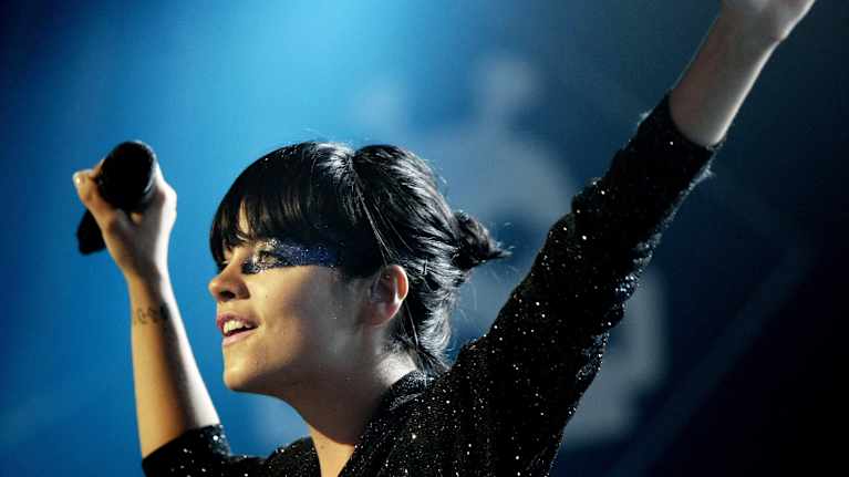 Lily Allen pitelee mikrofonia esiintymislavalla.