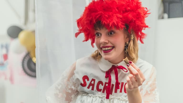 Nuori nainen (näyttelijä Anna Airola) vappuperuukki päässään.