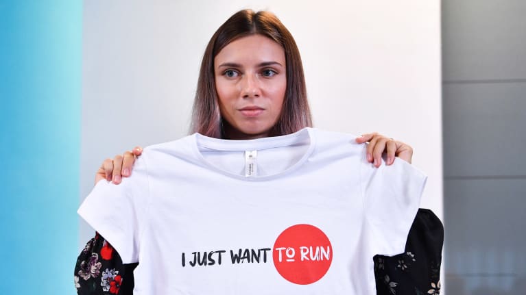 Krystsina Tsimanouskaya näyttää T-paitaa jossa lukee "I just want to run".