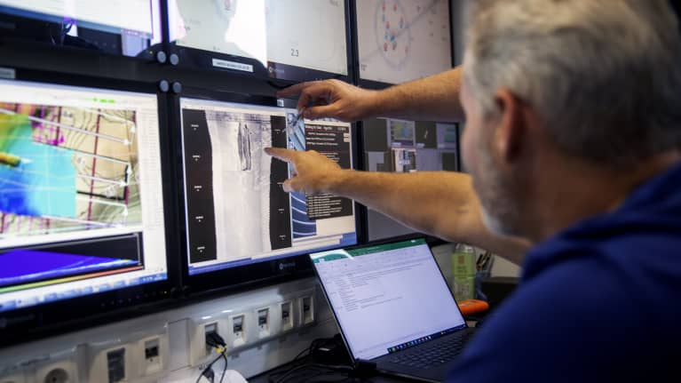 Estonia-aluksen hylkyä ja merenpohjaa tutkittiin heinäkuussa 2021, tutkijat katsovat pohjasta otettuja kuvia tutkimusaluksella.