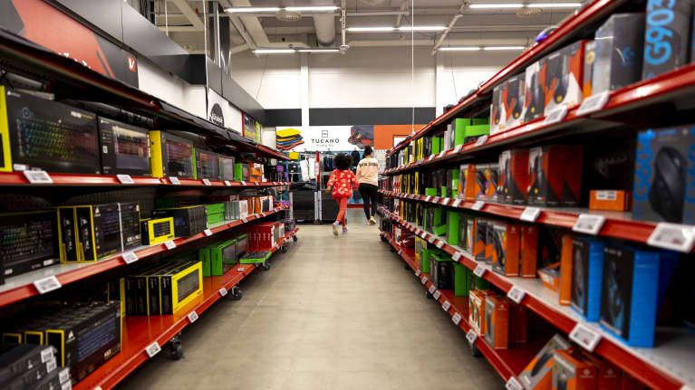 Vanhempi ja lapsi kulkevat Verkkokauppa.comin käytävää.