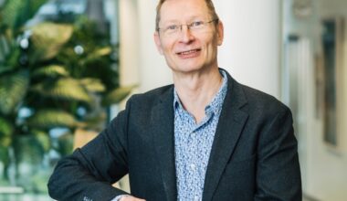 Anssi Auvinen katsoo kameraan, taustalla huonekasveja.