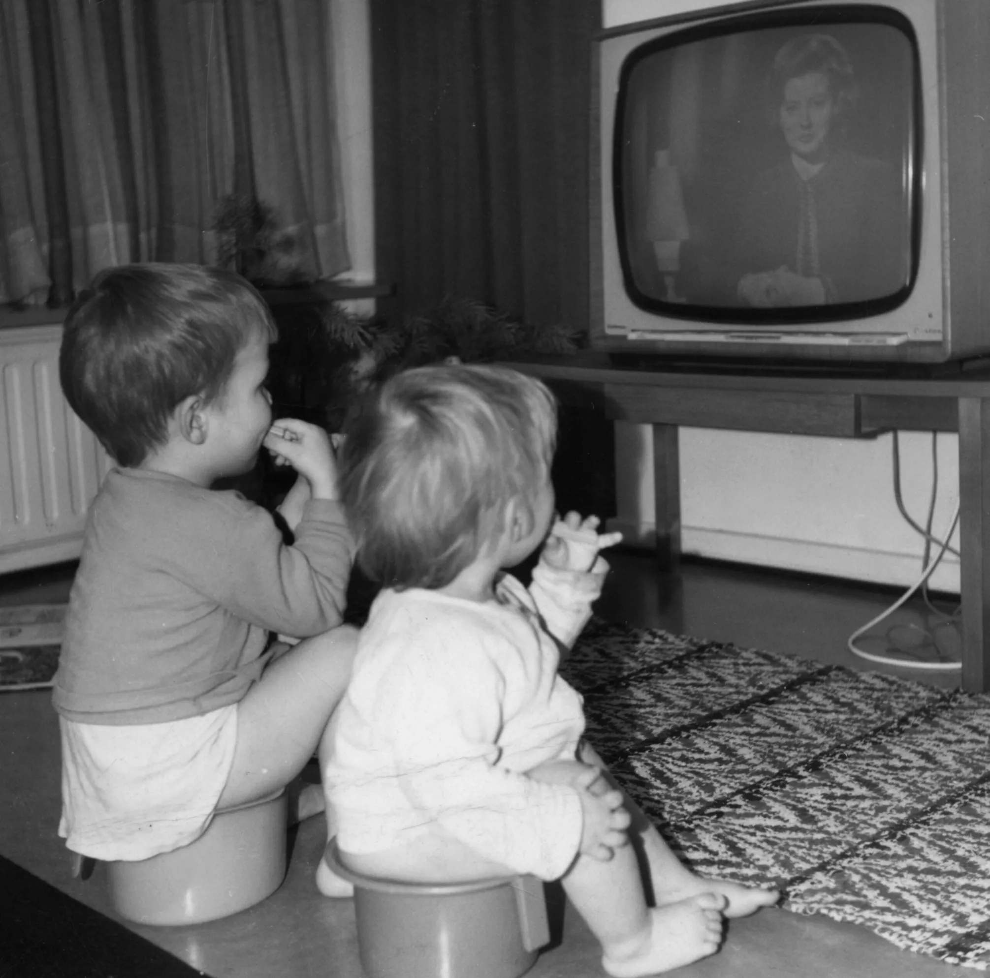 Lapset syövät ja katselevat televisiota potalla istuen 1970-luvulla.