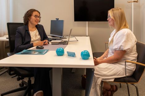 Tiina keskustelee pankissa asiantuntija Miia Rintamäen kanssa siitä, miten hän voisi toimia lapsilleen hyvänä talouskasvattajana.