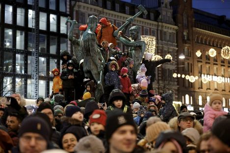 Perheen pienimmät nousivat Kolmen sepän patsaan päälle.