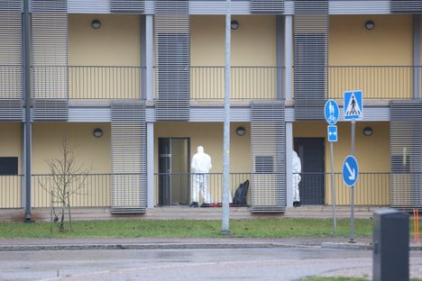 Valkopukuiset tutkijat surma-asunnolla.