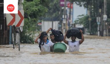 Tulvien uhrit kahlaavat tulvineella tiellä rankkasateen aikana Colombon esikaupungissa Sri Lankassa 29. marraskuuta 2025.