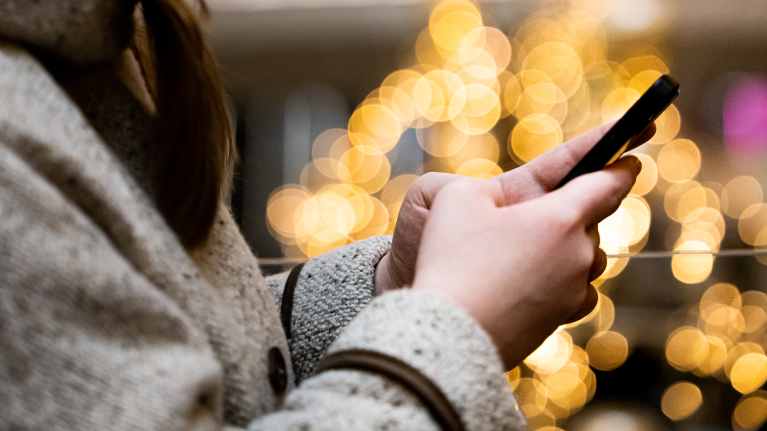 Henkilö tekstaa puhelimella.