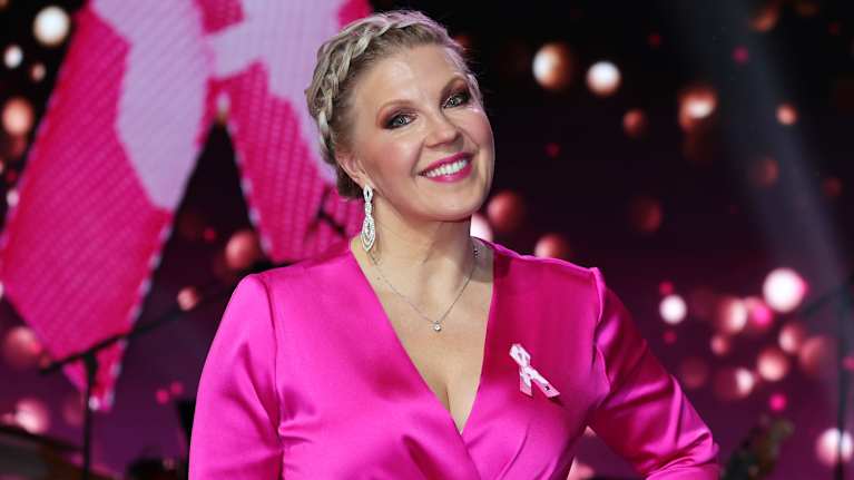 Vappu Pimiä katsoo kameraan pikku asu päällään.