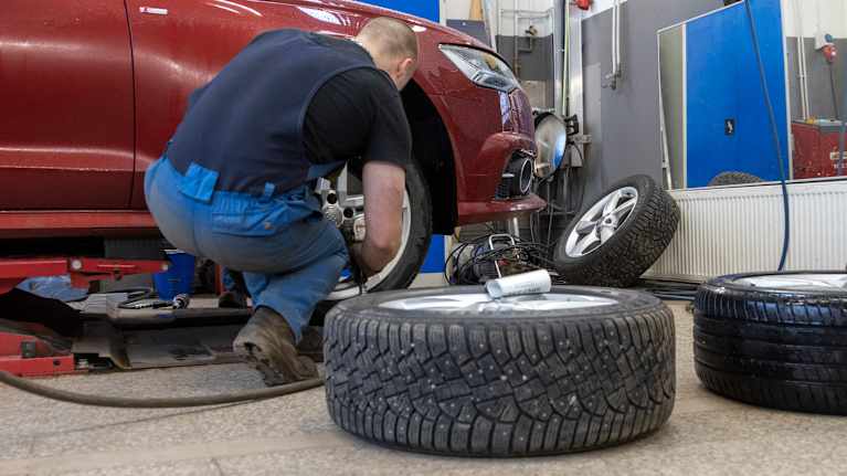 rengasasentaja irrottaa auton rengasta mutterinvääntimellä.