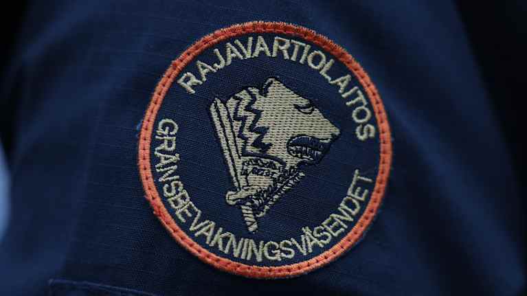 Pyöreä kangasmerkki, jossa on keskellä karhun pää ja lukee rajavartiolaitos gränsbevakningsväsendet.