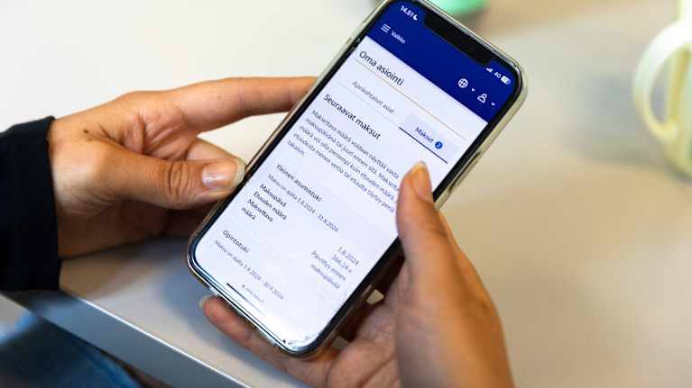 Henkilö selaa Kelan Omakelaa, jossa kerrotaan asumistuen seuraavasta maksusta.