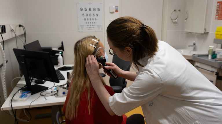 Terveyskeskuslääkäri Vilma Halme,  tutkii potilaan korvaa.