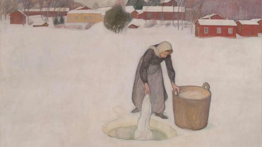 Kuvassa on vanhanaikaisesti pukeutunut nainen pesemässä pyykkiä avannossa talvisessa maisemassa. Taustalla näkyy lumisia punaisia ja keltaisia rakennuksia sekä lumisia puita."