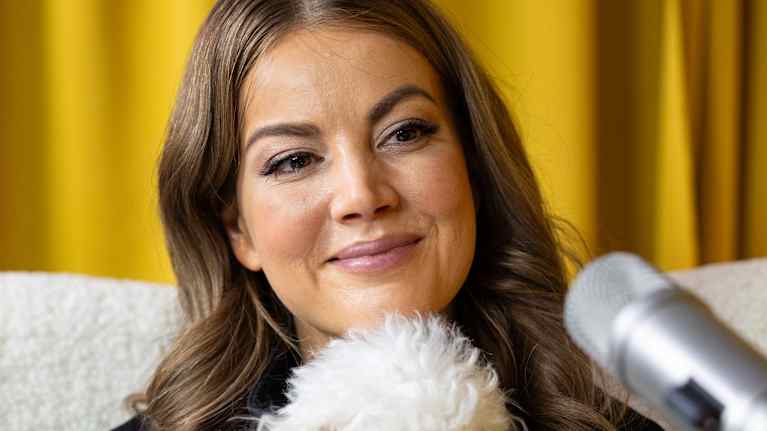 Janni Hussi Harri-koiran kanssa podcast-studiossa.