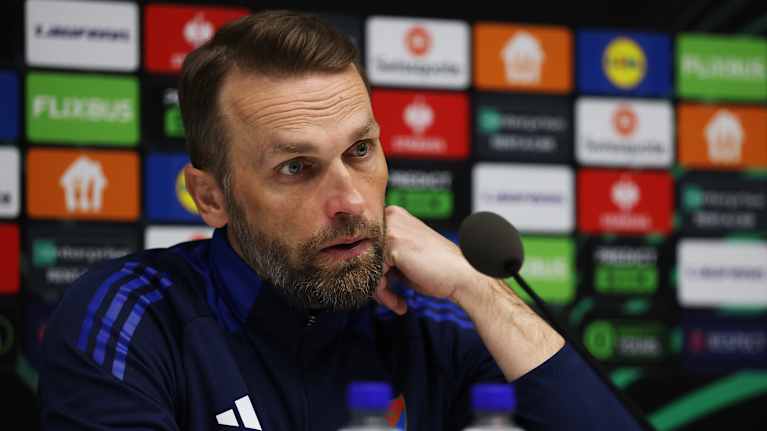 Jalkapallovalmentaja Jani Honkavaara puhuu mikrofoniin lehdistötilaisuudessa.