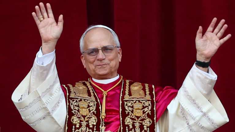 Paavi vilkuttaa ihmisille parvekkeelta.