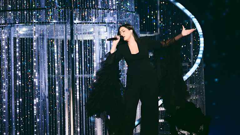 Yuval Raphael laulaa lavalla mustassa mekossa, jossa on pitkät rimpsuhihat.