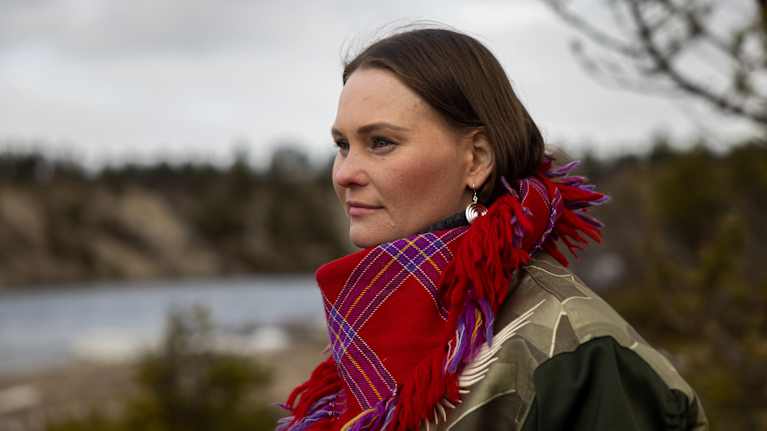 Nainen jokitörmällä.