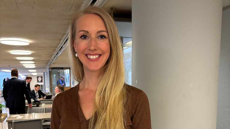 nainen seisoo ja katsoo kameraan.