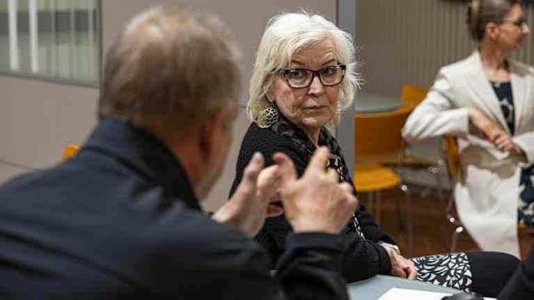 Kuvassa keskustellaan pöydän ääressä.