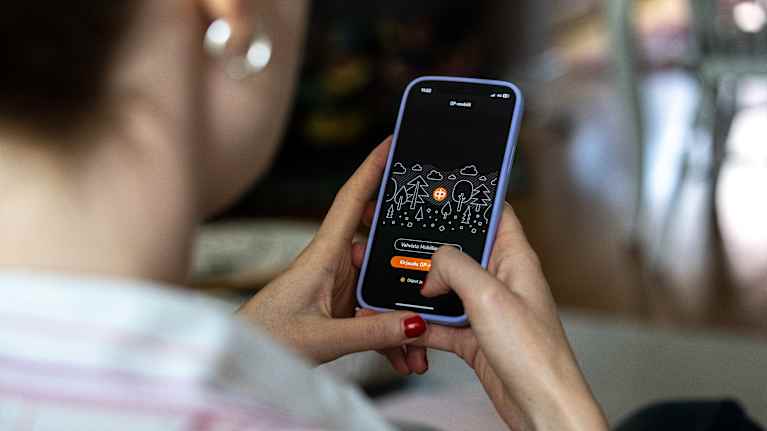 Henkilö on aukaisemassa puhelimeltaan OP-pankin sovelluksen.