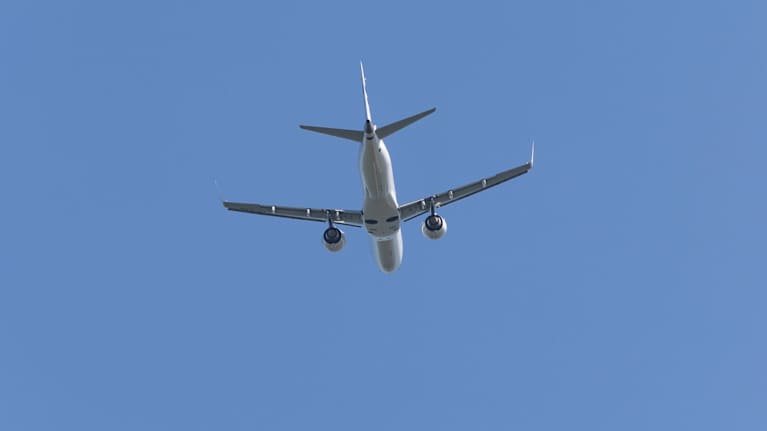 Finnairin lentokone nousussa, alhaalta ja takaapäin kuvattuna.