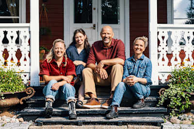 Kolme naista ja mies pitsihuvilan rappusilla.