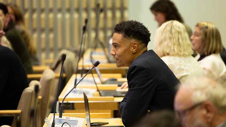 Kaupunginvaltuutettu Shawn Huff (Vihr.) istuu valtuustosalissa.