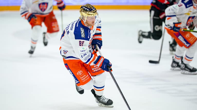 Tappara-joukkueen pelaaja kontrolloi kiekkoa jääkiekkokentällä.